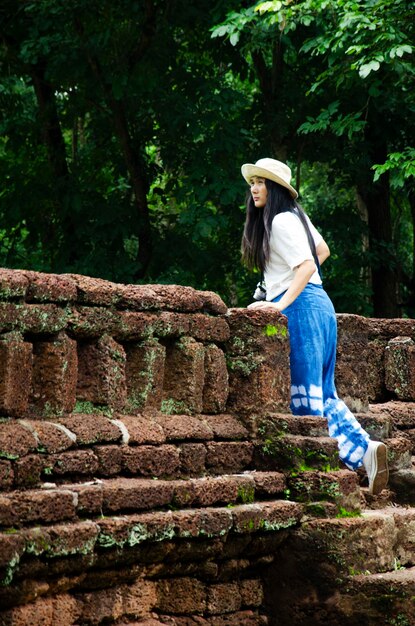 Podróżnicy tajlandzka kobieta spacerująca odwiedzają i podróżują robią zdjęcia w starożytnym budynku i ruinach Parku Historycznego Kamphaeng Phet to stanowisko archeologiczne i obszar Aranyik w Kamphaeng Phet Tajlandia