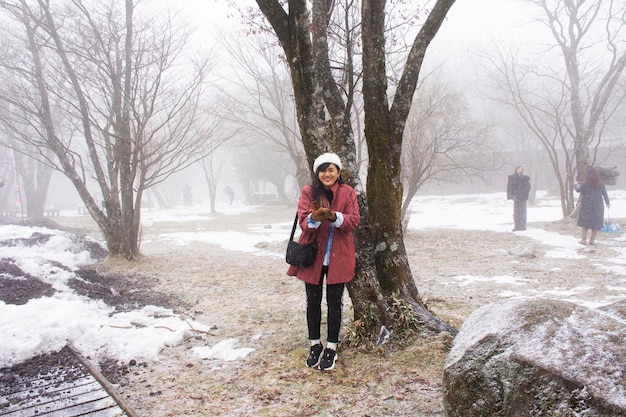 Podróżnicy z Tajlandii odwiedzają kobiety i pozują portret ze śniegiem padającym w lesie na wulkanie Hanla Mountain lub Mount Halla w Parku Narodowym Hallasan 17 lutego 2023 r. w Jejudo w Korei Południowej