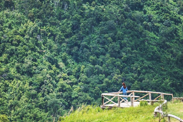 Podróżniczka patrząca na piękny widok na zielone góry na drewnianym balkonie