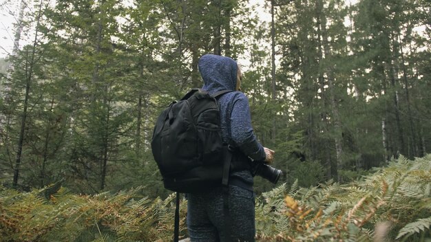 Podróżnik fotografujący malowniczy widok w lesie Jedna kaukaska kobieta strzelająca ładny magiczny wygląd Dziewczyna robi zdjęcie wideo na lustrzanym aparacie dslr