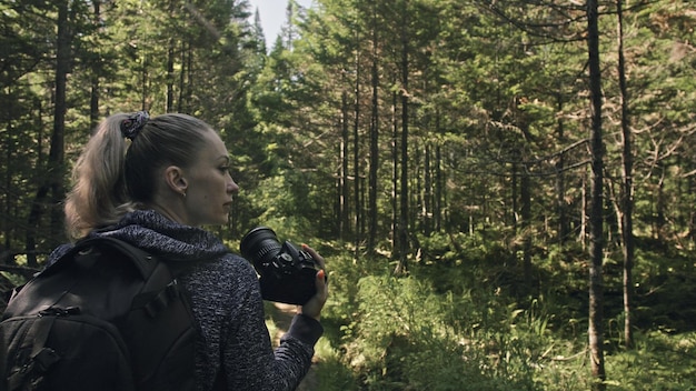 Podróżnik fotografujący malowniczy widok w lesie Jedna kaukaska kobieta strzelająca ładny magiczny wygląd Dziewczyna robi zdjęcie wideo na lustrzanym aparacie dslr
