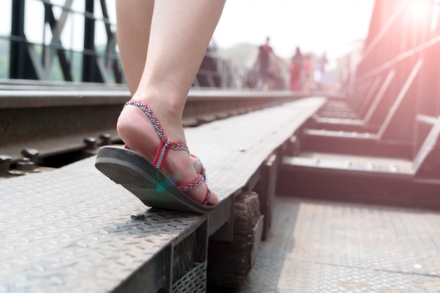 Zdjęcie podróżnik na butach sneakers podczas spaceru na most kolejowy