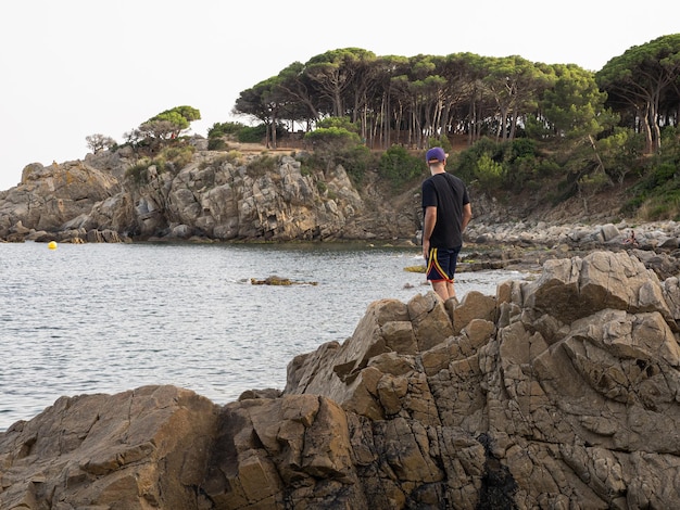 Podróżnik stojący pośród skał na tle morza Strzela od tyłu