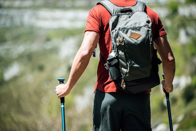 Podróżnik z plecakiem i kijkami trekkingowymi w górzystym terenie