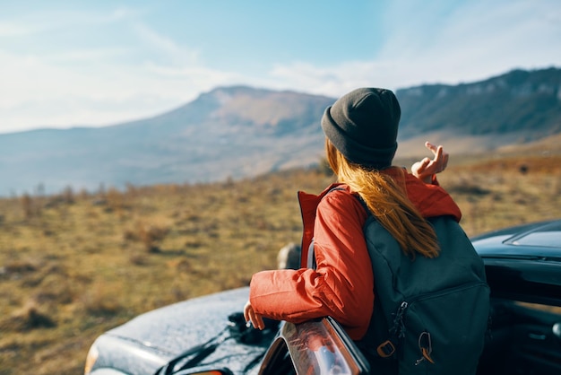 Podróżny z plecakiem w pobliżu samochodu w górach latem i niebieskie niebo świeże powietrze wysokiej jakości zdjęcie