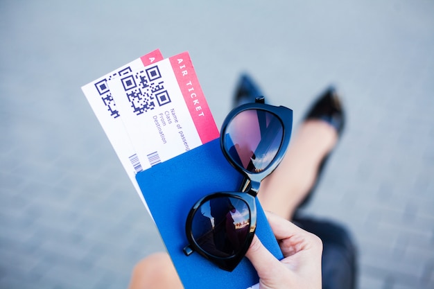 Podróżować. Kobieta trzyma dwa lotniczy bilet w zagranicznym paszporcie blisko lotniska
