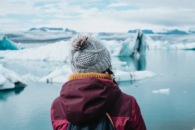 Podróżująca kobieta w ubraniach na zimno przed lodowcami Jokulsarlon na Islandii podczas nastrojowego dnia wypełnionego wodą Przeżyj swoją wymarzoną miłość w stylu islandzkiej wycieczki objazdowejSkopiuj przestrzeń