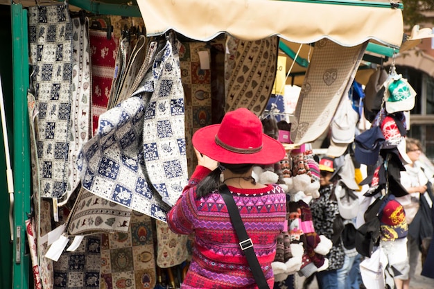 Podróżujące azjatyckie tajskie kobiety wybierają i kupują tkaniny i wyroby rzemieślnicze na ręcznie robionym targu ulicznym w mieście Maran w Merano we Włoszech