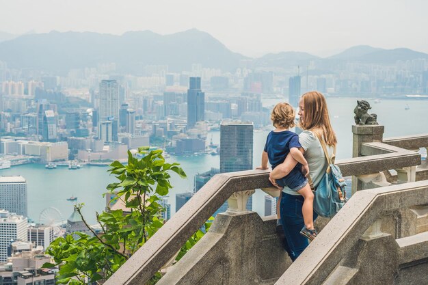 Podróżujący mama i syn na szczycie Wiktorii na tle Hongkongu. Podróżowanie z koncepcją dzieci