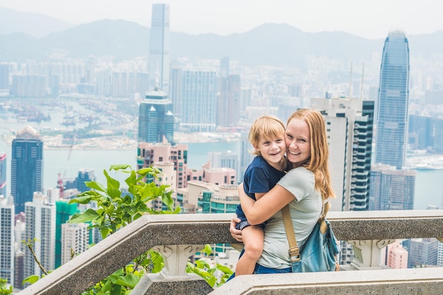 Podróżujący mama i syn na szczycie Wiktorii na tle Hongkongu. Podróżowanie z pojęciem dzieci.