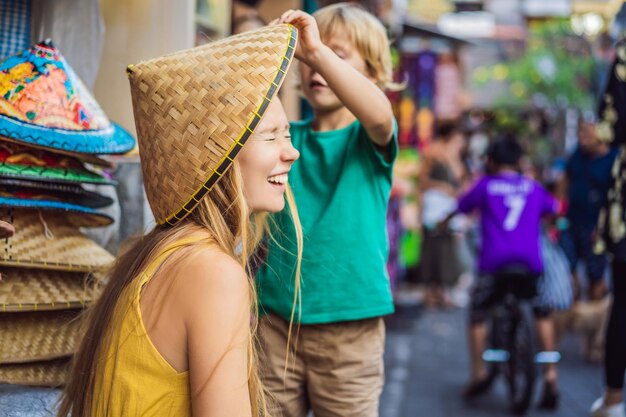 Podróżujący mama i syn wybierają pamiątki na targu w Ubud na Bali w Indonezji