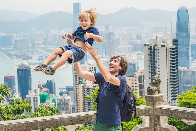 Podróżujący ojciec i syn na szczycie Wiktorii na tle Hongkongu. Podróżowanie z pojęciem dzieci.