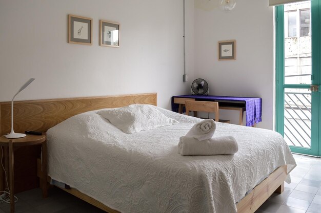 Podstawa łóżka sypialnia z matą na podłodze gliniany garnek w tle drewniana kredens i lustro
