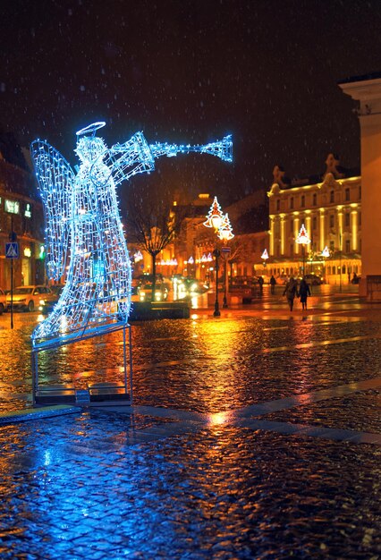 Podświetlana figura anioła na Rynku Starego Miasta w Wilnie w noc Bożego Narodzenia. Wilno, Litwa