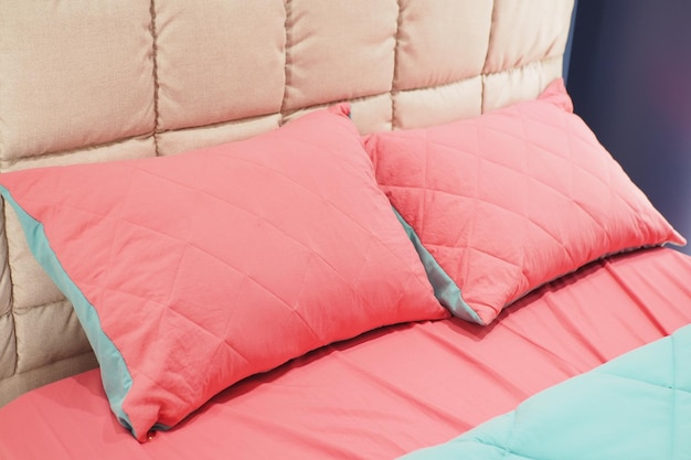 Poduszka w kolorze różowym ułożona na łóżku