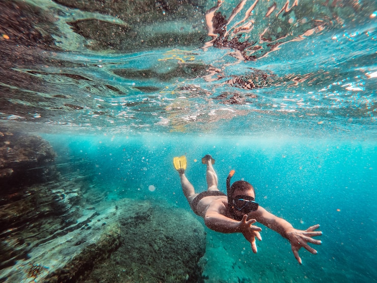 Zdjęcie podwodna fotografia mężczyzna nurek snorkeling w morzu