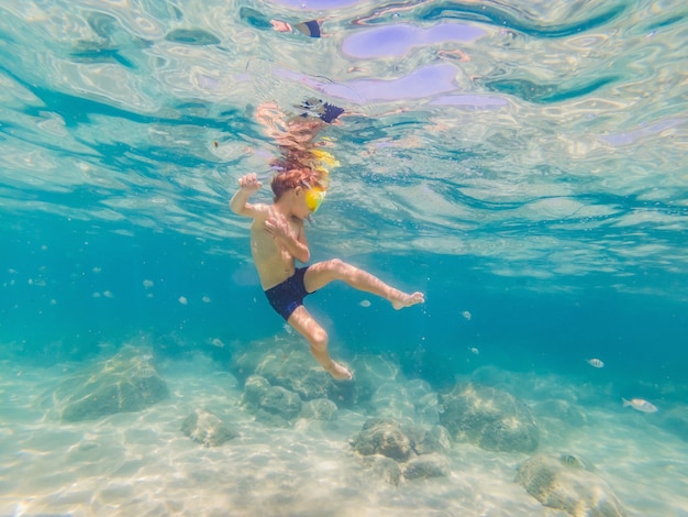 Podwodne studium przyrody, chłopiec nurkujący z rurką w czystym, błękitnym morzu