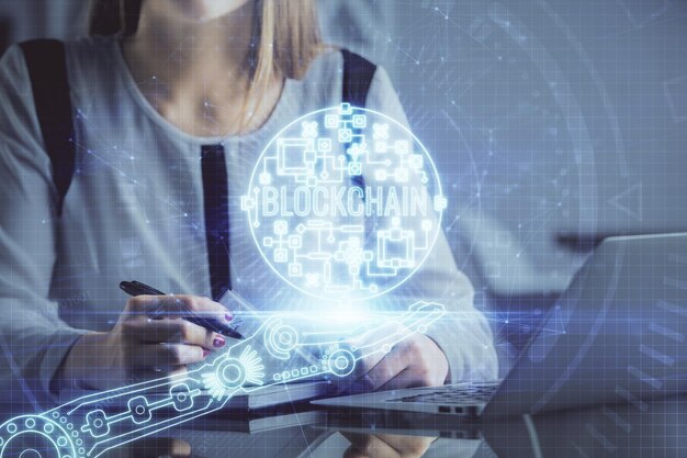 Podwójna ekspozycja dłoni kobiet piszących na komputerze i hologram na temat rynku kryptograficznego rysunek koncepcji Blockchain