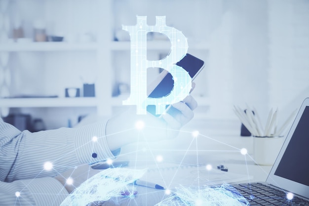 Podwójna ekspozycja dłoni mężczyzny trzymającego i używającego rysunku motywu blockchain telefonu i kryptowaluty