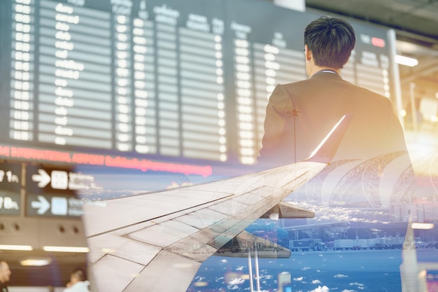 Podwójna ekspozycja samolotu i biznesmena w bramce terminalu do odprawy na pokład z bagażem i telefonem na lotnisku w podróży służbowej.