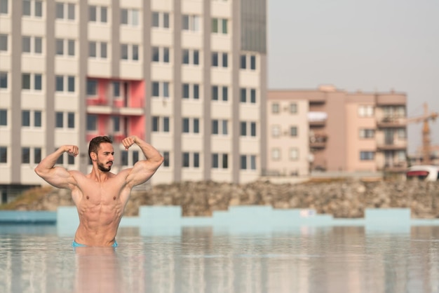 Zdjęcie podwójny biceps pozuje na basenie