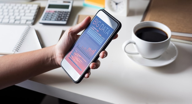 Pojęcia dużych zbiorów danych z osobą trzymającą smartfon pokazuje informacje o danych