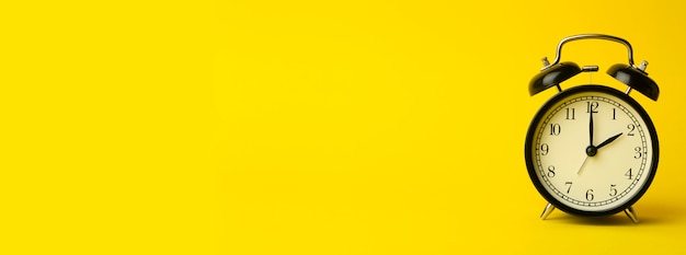 Zdjęcie pojęcie czasu w tle. rocznika klasyczny budzik na koloru żółtego pustym tle. comcept zarządzania czasem