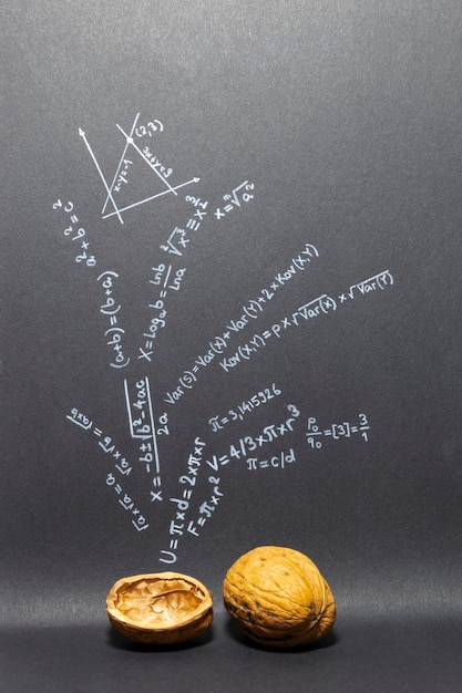 Pojęcie frazy matematyka w skrócie formuły matematyczne na czarnym papierze z orzechami włoskimi