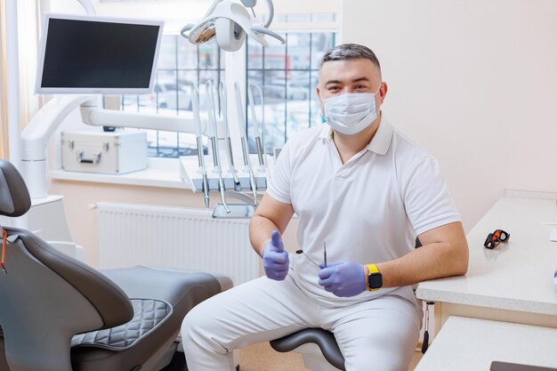 Pojęcie medycyny zawód stomatologia i medycyna uśmiechnięty dentysta w średnim wieku na tle gabinetu lekarskiego Dentysta jest w swoim gabinecie stomatologicznym