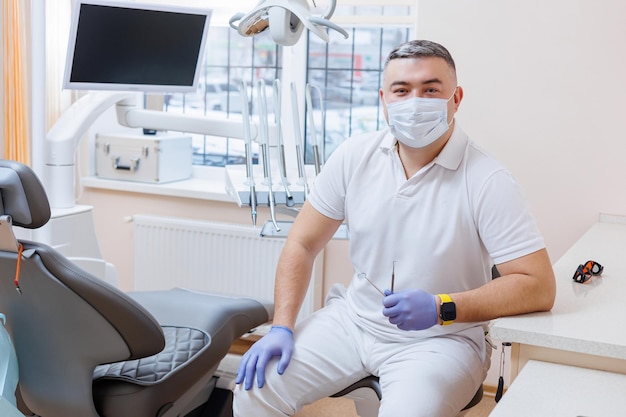 Pojęcie medycyny zawód stomatologia i medycyna uśmiechnięty dentysta w średnim wieku na tle gabinetu lekarskiego Dentysta jest w swoim gabinecie stomatologicznym