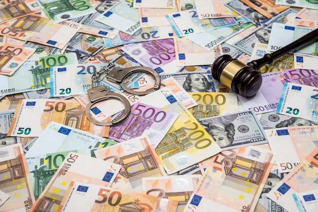 Pojęcie przestępczości kajdanki, młotek dolara i rachunki w euro