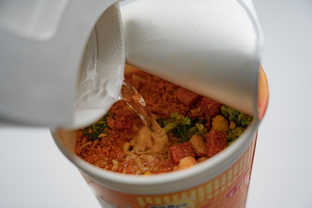 Pojemnik na zupę błyskawiczną z białą pokrywką i białą etykietą z napisem „makaron”.