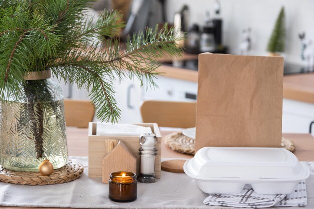 Pojemniki z dostawą żywności na stole w białej kuchni odświętnie podawane na obchody świąt bożego narodzenia i nowego roku Oszczędność czasu makieta jednorazowego plastikowego pudełka na zamówienie na gorąco
