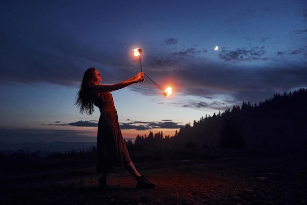 Pokaz ognia przez kobietę w sukience w nocy Karpaty Piękny krajobraz