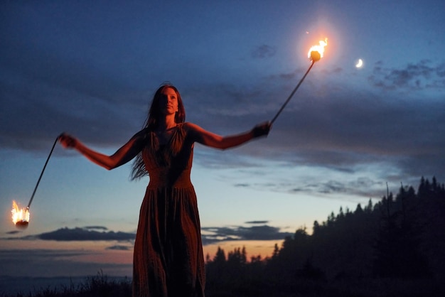 Pokaz ognia przez kobietę w sukience w nocy Karpaty Piękny krajobraz