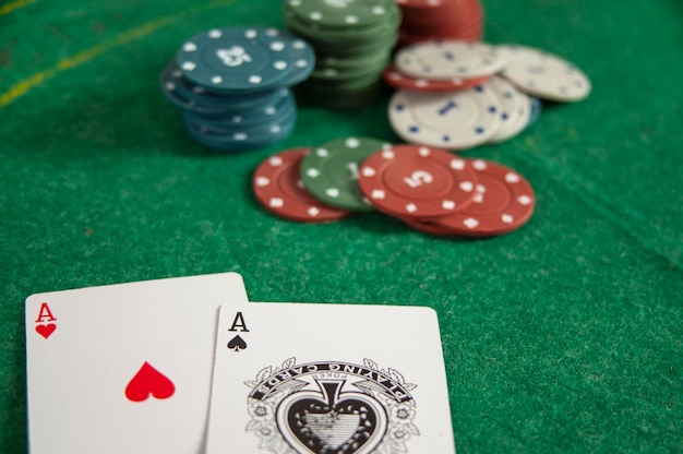 Pokerowe żetony i karty na zielonym tle