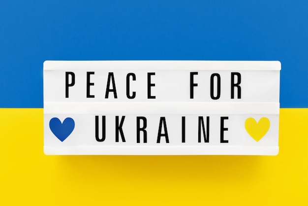 Pokój dla Ukrainy napisany w lightboxie na tle kolorów flagi ukraińskiej