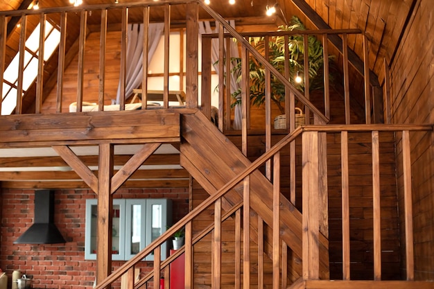 Pokój z drewnianymi schodami prowadzącymi na drugie piętro nowoczesnego mieszkania.