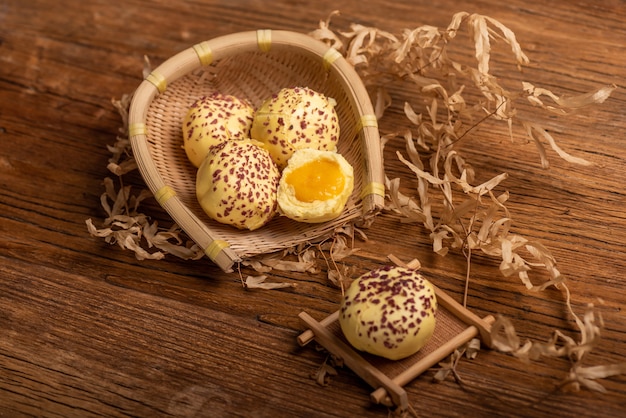 Zdjęcie pokrój i uzupełnij nadziewaną na parze bułkę z żółtkiem jajka na stole z drewna