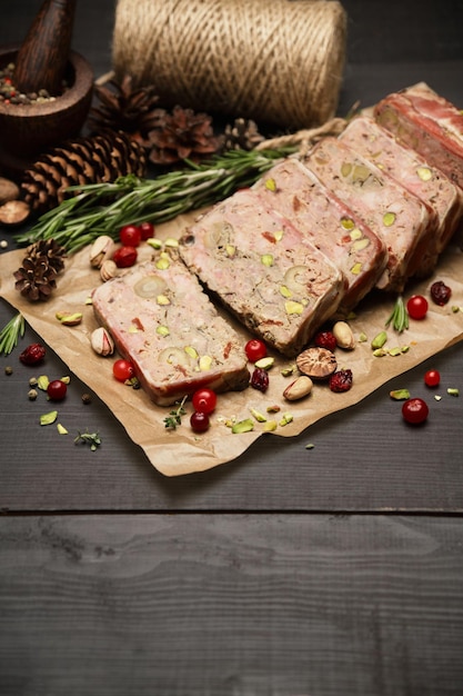 Zdjęcie pokrojona tradycyjna francuska terrina pokryta boczkiem na ciemnym drewnianym tle