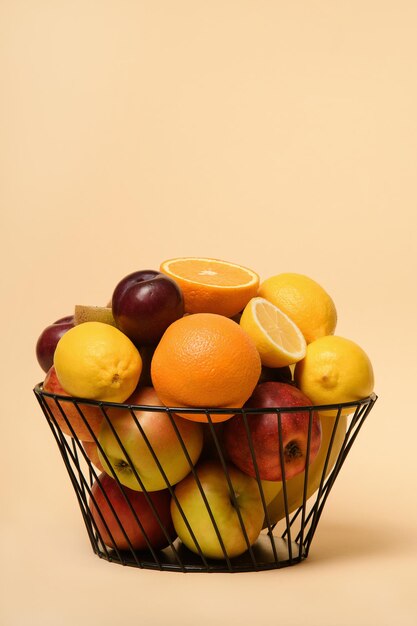 Pokrojone owoce w metalowym koszu Miejsce na tekst Jabłka banany pomarańcze kiwi śliwki