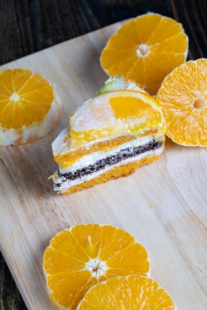 Pokrojone świeże pomarańcze i kawałek pomarańczowego deseru