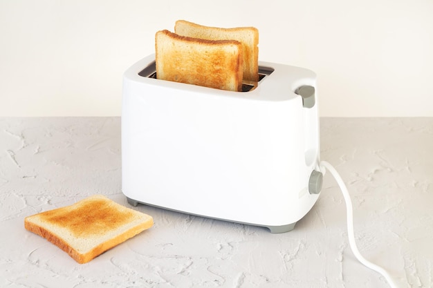 Pokrojony chleb tostowy na śniadanie w tosterze na stole kuchennym