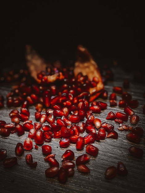 Zdjęcie pokrojony czerwony granat z nasionami na ciemnym tle widok z boku