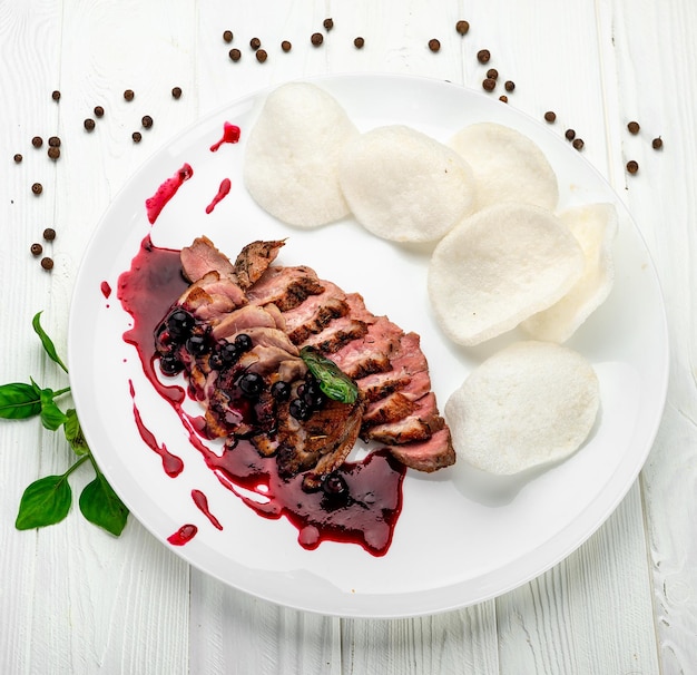 Pokrojony stek wołowy z sosem jagodowym na drewnianej desce Serwowanie w restauracji Zdjęcie do menu restauracji