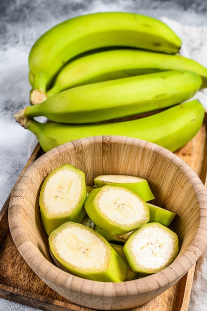 Pokrojony zielony banan w drewnianej misce.