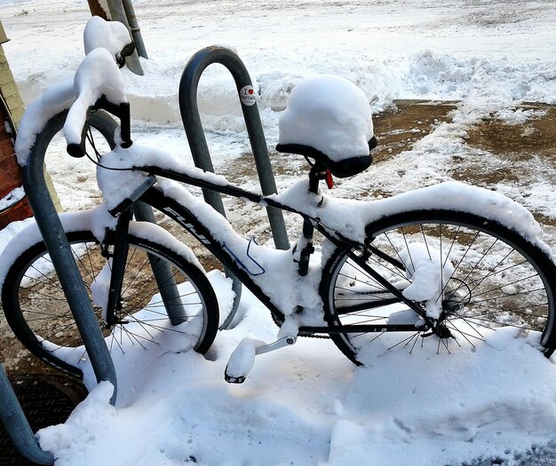 Zdjęcie pokryty śniegiem rower zaparkowany na polu