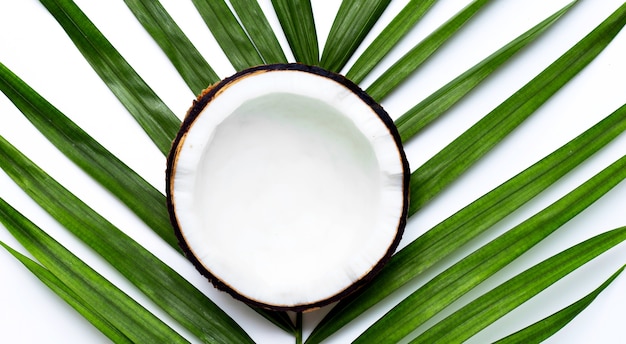 Pół kokosa na liściach tropikalnej palmy. Widok z góry