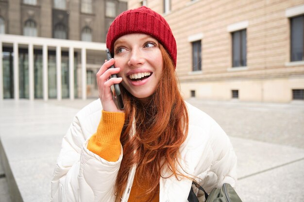 Połączenie mobilne i koncepcja ludzi szczęśliwa ruda kobieta w kapeluszu rozmawia przez telefon komórkowy co telepho