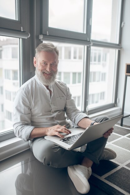 Połączony. Mężczyzna Siedzący Na Podłodze I Pracujący Na Laptopie